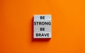 Be strong be brave symbol. Wooden blocks with words `be strong be brave`. Beautiful orange background. Copy space. Motivational,