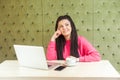 Be waiting an idea! Portrait of dreaming attractive young girl freelancer with black dreadlocks hairstyle in pink blouse sitting