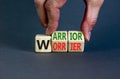 Be warrior not worrier symbol. Concept words Warrior and Worrier on wooden cubes. Businessman hand. Beautiful grey table grey