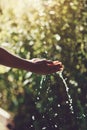 Be wise with water. Closeup shot of a man holding his hands under a stream of water outdoors. Royalty Free Stock Photo