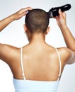 Be a woman who do does what she wants. Rearview shot of a young woman shaving her head against a white background.