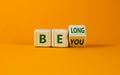 Be you, belong symbol. Turned a cube and changed words `be you` to `belong`. Beautiful orange background. Business, belonging