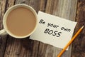 Be Your Own Boss motivational inscription on white paper, with cup of coffee over rustci wooden table. Royalty Free Stock Photo