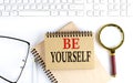 BE YOURSELF text in the office notebook with keyboard, magnifier and glasses , business concept Royalty Free Stock Photo