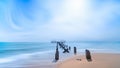 Beach with abandoned ruin pier over blue sea and sky Royalty Free Stock Photo