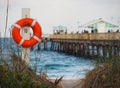 Beach access next to pier and lifeguard float hanging from pole