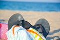 Beach accessories as sunglasses, slippers, towel, toys on sand