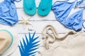 Beach accessories bikini swimsuit, hat, bag, flip flops on a white wooden background. Travel concept. Female fashionable summer Royalty Free Stock Photo