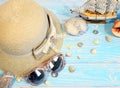 Beach accessories on a blue board aquamarine color background.  Female hat, sunglasses, sea shells, sea stones. Travel and tourism Royalty Free Stock Photo