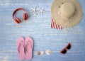 Beach accessories on blue wooden plank  summer holiday on the beach concept  hat  red headphones seashell  starfish  towel and Royalty Free Stock Photo