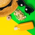 Beach accessories on a bright neon colorful background. A fragment of a straw hat and sea urchin shell , shells necklace, a bottle Royalty Free Stock Photo