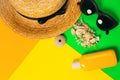 Beach accessories on a bright neon colorful background. A fragment of a straw hat and sea urchin shell , shells necklace, a bottle Royalty Free Stock Photo