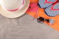 Beach accessories. Flip-flops, hat and glasses on an orange towel on the sea sand Royalty Free Stock Photo