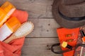 Beach accessories - hairbrush, orange towel, hat, sun cream, lotion, beach bag, nail polish, a book on brown wooden background Royalty Free Stock Photo