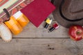 Beach accessories hairbrush, orange towel, hat, sun cream, lotion, beach bag, nail polish, a book on a brown wooden background Royalty Free Stock Photo