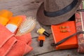 Hairbrush, orange towel, hat, sun cream, lotion, beach bag, nail polish, a book on a brown wooden background Royalty Free Stock Photo