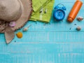 Beach accessories including sunscreen, hat beach, shell and retro camera on bright blue pastel wooden background for summer Royalty Free Stock Photo