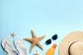 Beach accessories on light blue background, flat lay. Space for text Royalty Free Stock Photo