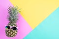 Beach accessories pineapple with pink sunglasses on pink, green and yellow background for summer holiday and vacation concept Royalty Free Stock Photo