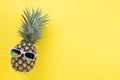 Beach accessories pineapple with pink sunglasses on yellow background for summer holiday and vacation concept Royalty Free Stock Photo