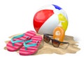 Beach accessories for relaxing. Sunscreen bottle, flip flops, sunglasses and ball onthe sand.