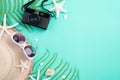 Beach accessories retro film camera, sunglasses, flip flop, starfish beach hat and sea shell on bright pastel green background for Royalty Free Stock Photo