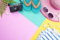 Beach accessories retro film camera, sunglasses, flip flop starfish beach hat and sea shell on pink and yellow background for Royalty Free Stock Photo