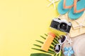 Beach accessories retro film camera, sunglasses, flip flop starfish beach hat and sea shell on yellow pastel background for summer Royalty Free Stock Photo