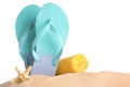 Beach accessories on sand against white background