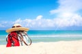 Beach accessories on sand for summer vacation concept. Bag, straw hat with sunglasses and red flip flops. White sand with amazing Royalty Free Stock Photo