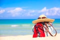 Beach accessories on sand for summer vacation concept. Bag, straw hat with sunglasses and red flip flops. White sand with amazing Royalty Free Stock Photo