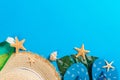 Beach accessories with straw hat and seashells on blue background top view with copy space Royalty Free Stock Photo