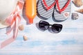 Beach accessories. summer hat , cream, black glasses and sea shells on a blue wooden background. Top view Royalty Free Stock Photo