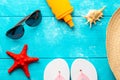 Beach accessories. Summer holidays and vacation travel concept. Sunscreen lotion bottle, straw hat, flip flops, shell, sunglasses Royalty Free Stock Photo