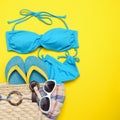 Beach accessories on the yellow background - Sunglasses, bikini, flip-flops and striped hat. Summer is coming concept Royalty Free Stock Photo