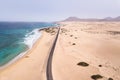 Beach aerial view with a road along ocean coast and sand dunes in Fuerteventura, Canary Islands viewed from drone, scenic Royalty Free Stock Photo
