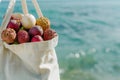beach bag brimming with lychees, passion fruits, and starfruits by the sea Royalty Free Stock Photo