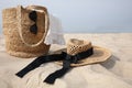 Beach bag, towel, sunglasses and hat on sandy seashore, space for text Royalty Free Stock Photo