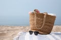 Beach bag, towels, sunglasses and blanket on sandy seashore, space for text Royalty Free Stock Photo