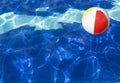 Beach ball floating in swimming pool. Royalty Free Stock Photo