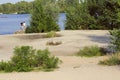 Beach on the banks of the river. Girl and boy standing on shore