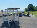 beach bar with no people during the day. furniture, chairs, table and floor in wood. a warm sunny day for a seaside holiday. Royalty Free Stock Photo