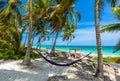 Beach beds and Hammock under the palm trees on paradise beach at tropical Resort. Riviera Maya - Caribbean coast at Tulum in Royalty Free Stock Photo