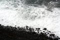 Beach of black rocks and wild sparkling waters. Royalty Free Stock Photo