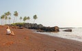 Beach with black sand and palm trees. Dark brown volcanic sand a Royalty Free Stock Photo