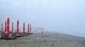 Beach of Black Sea from Mamaia, Romania with sunbeds and umbrellas, foggy day. Royalty Free Stock Photo