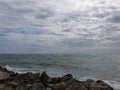 Beach with Black Stones and sky is full of clouds ,sun is also blocked by clouds Royalty Free Stock Photo