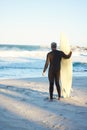 Beach, board and man surfing on holiday for travel and adventure by the water in Hawaii. Back of surfer by the ocean for