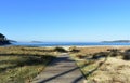 Beach with boardwalk, grass and vegetation in sand dunes. Blue sea, sunny day, clear sky. Galicia, Spain. Royalty Free Stock Photo