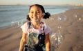 Beach, bubbles and a girl playing at sunset, having fun and enjoying an ocean trip. Freedom, energy and child running Royalty Free Stock Photo